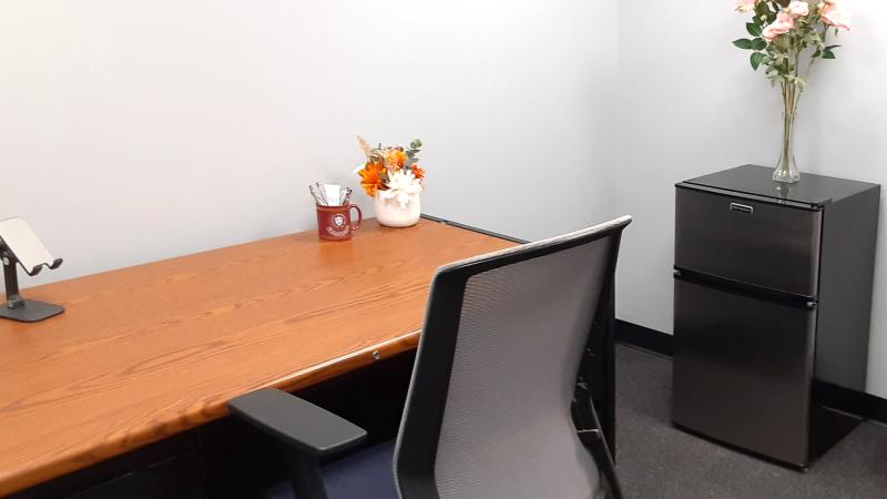 view of office from inside showing desk, chair, and minifridge